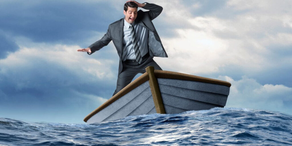 Businessman panicking in sinking boat.